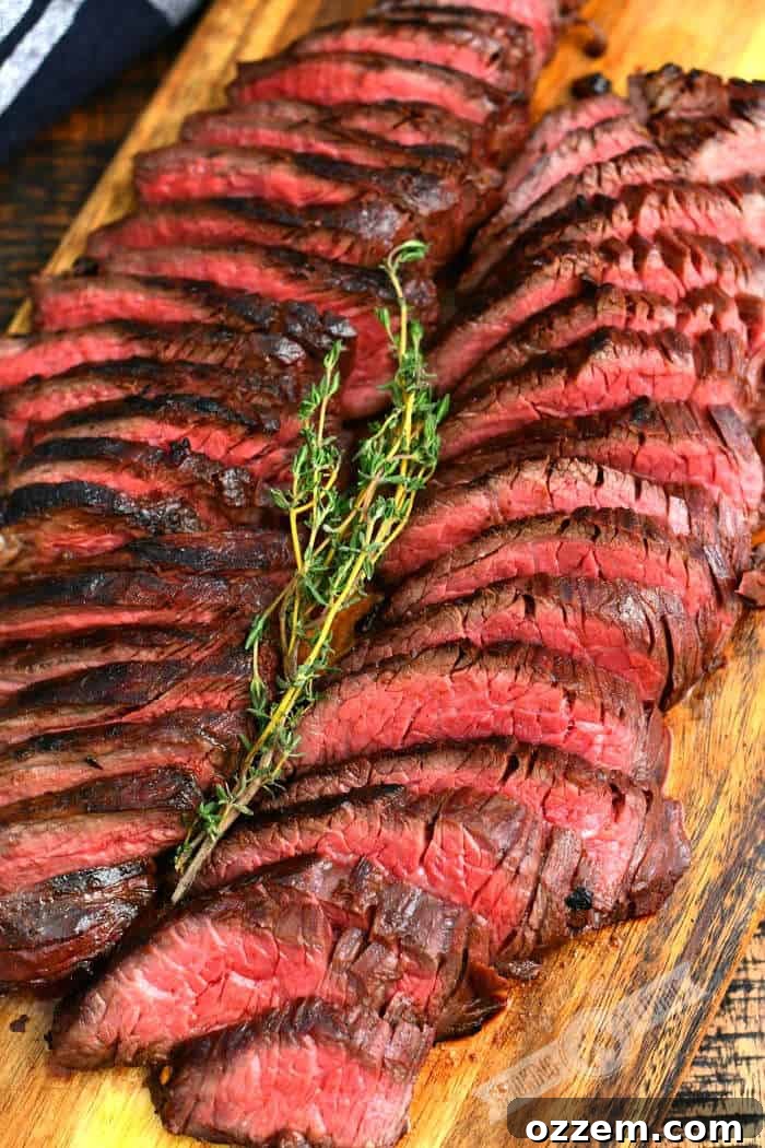 Fire Kissed Hanger Steak 2 Thinly sliced grilled hanger steak garnished with a sprig of thyme