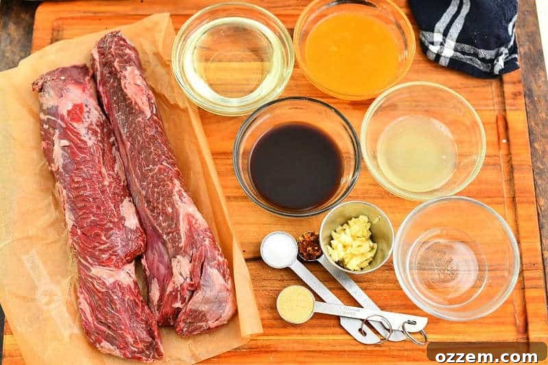 Fire Kissed Hanger Steak 3 Two raw hanger steaks laid out with marinade ingredients on a wooden cutting board