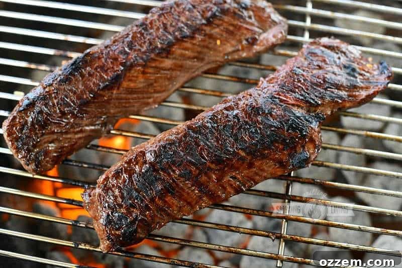 Fire Kissed Hanger Steak 7 Two long hanger steaks grilling over charcoal