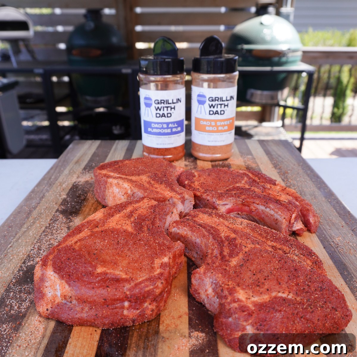 Raw pork chops generously seasoned with dry rub, ready for grilling.