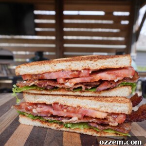 A close-up of the Maple Bourbon BLT, showcasing the layers of crispy bacon, fresh lettuce, and ripe tomato with spicy mayo.