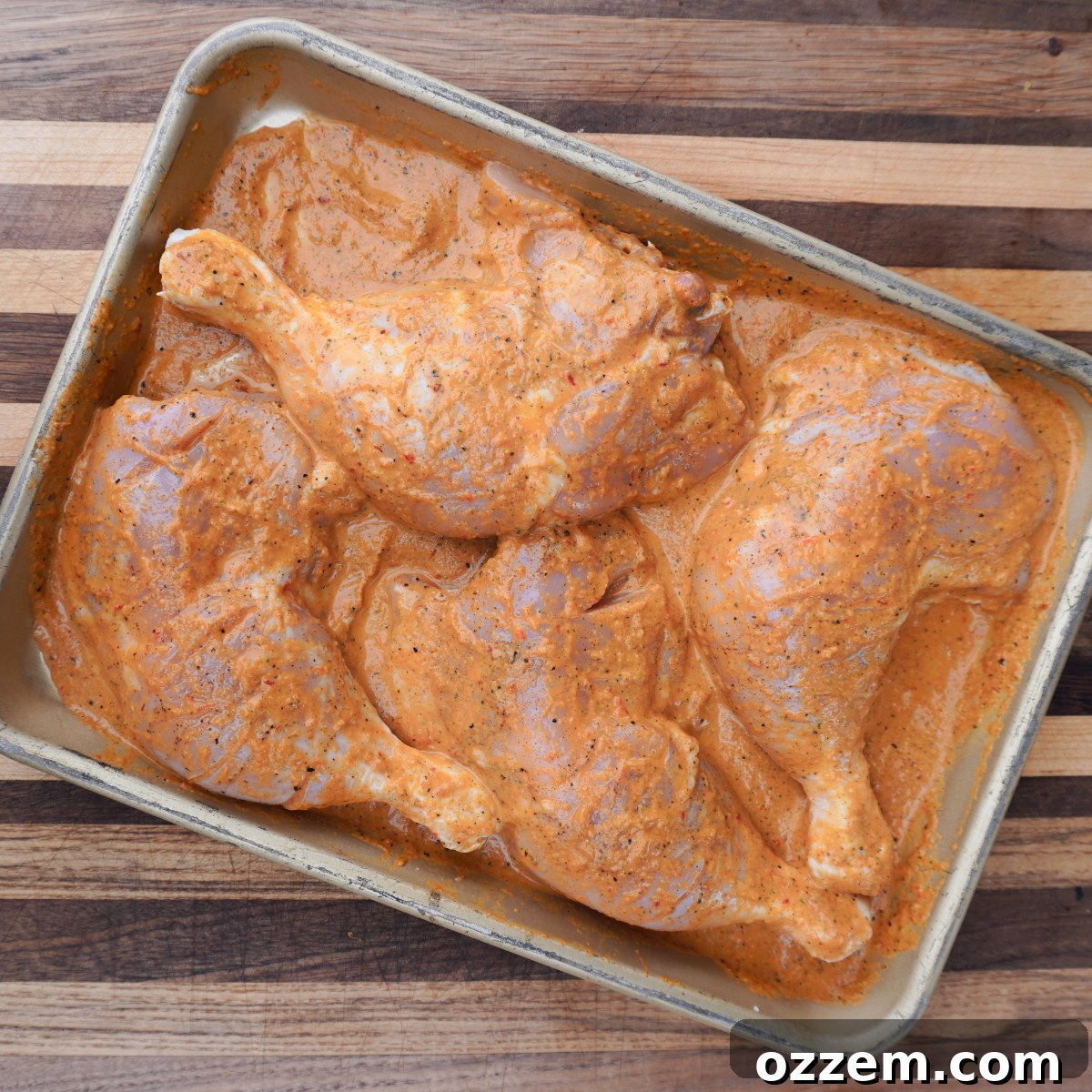 Chicken leg quarters scored and marinating in homemade Peri Peri sauce.