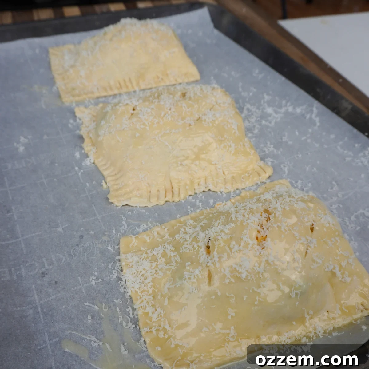 Savory Puff Pastry Parcels 5 Puff pastry pockets sealed with a fork, ready for cooking.