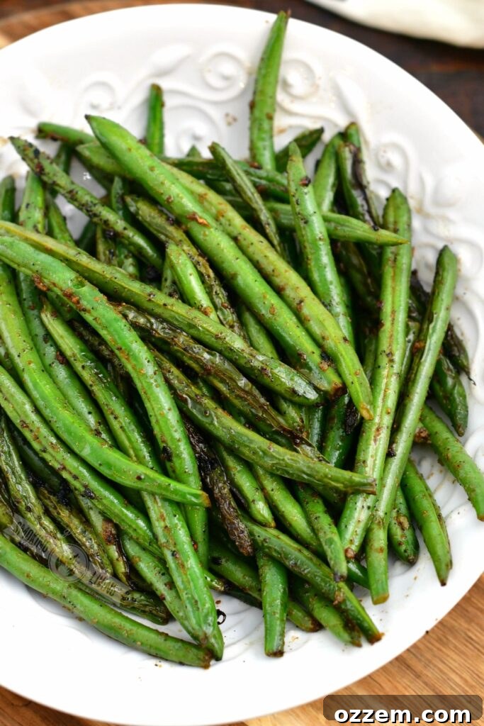 top view of grilled green beans in a white bowl