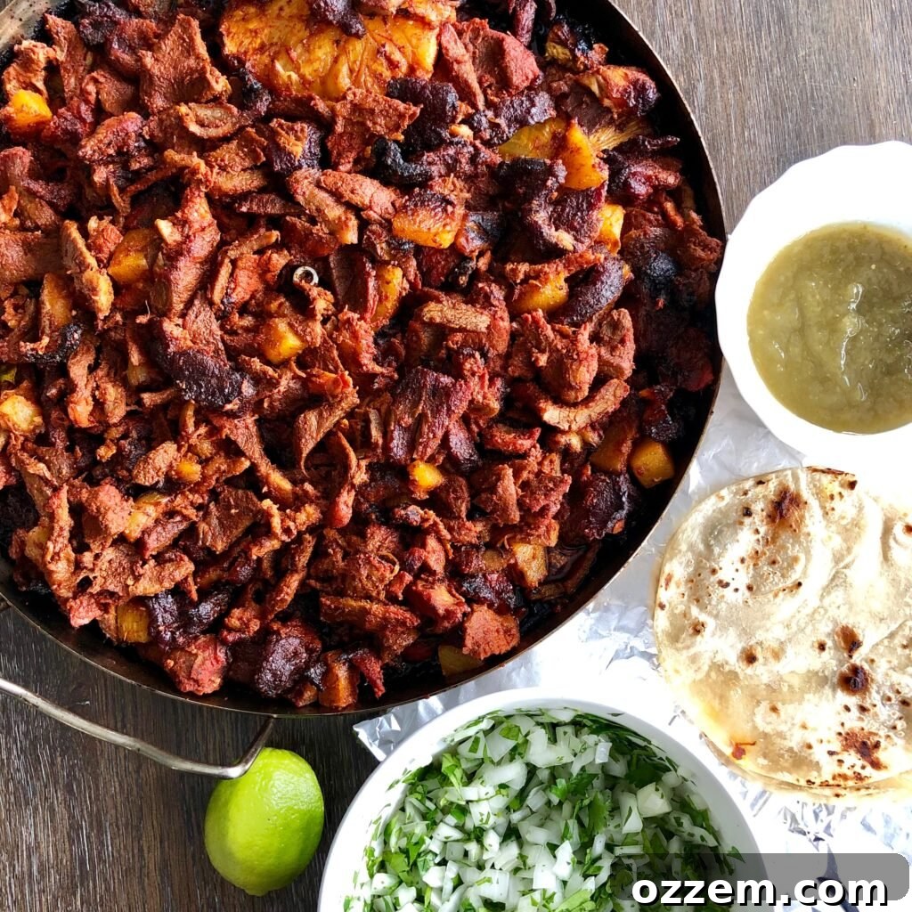 Beautifully cooked Al Pastor meat on a vertical skewer, ready to be sliced for tacos.