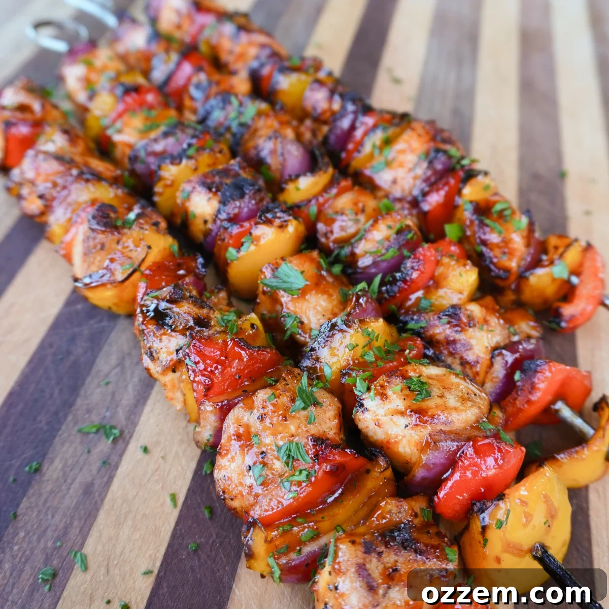 Close-up of perfectly grilled chicken and vegetable skewers, garnished with fresh herbs.