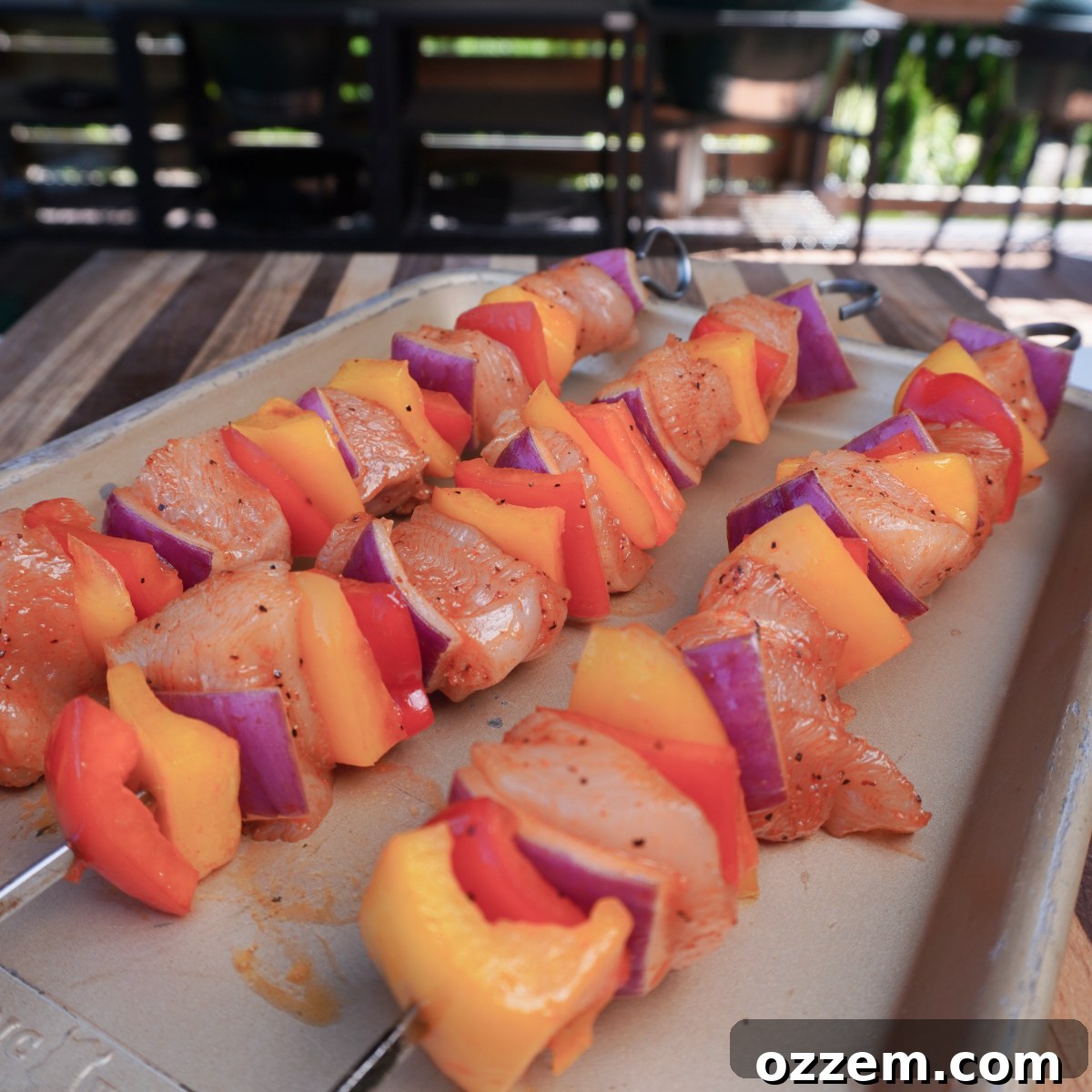 Raw chicken and vegetable skewers perfectly arranged, ready for the grill.