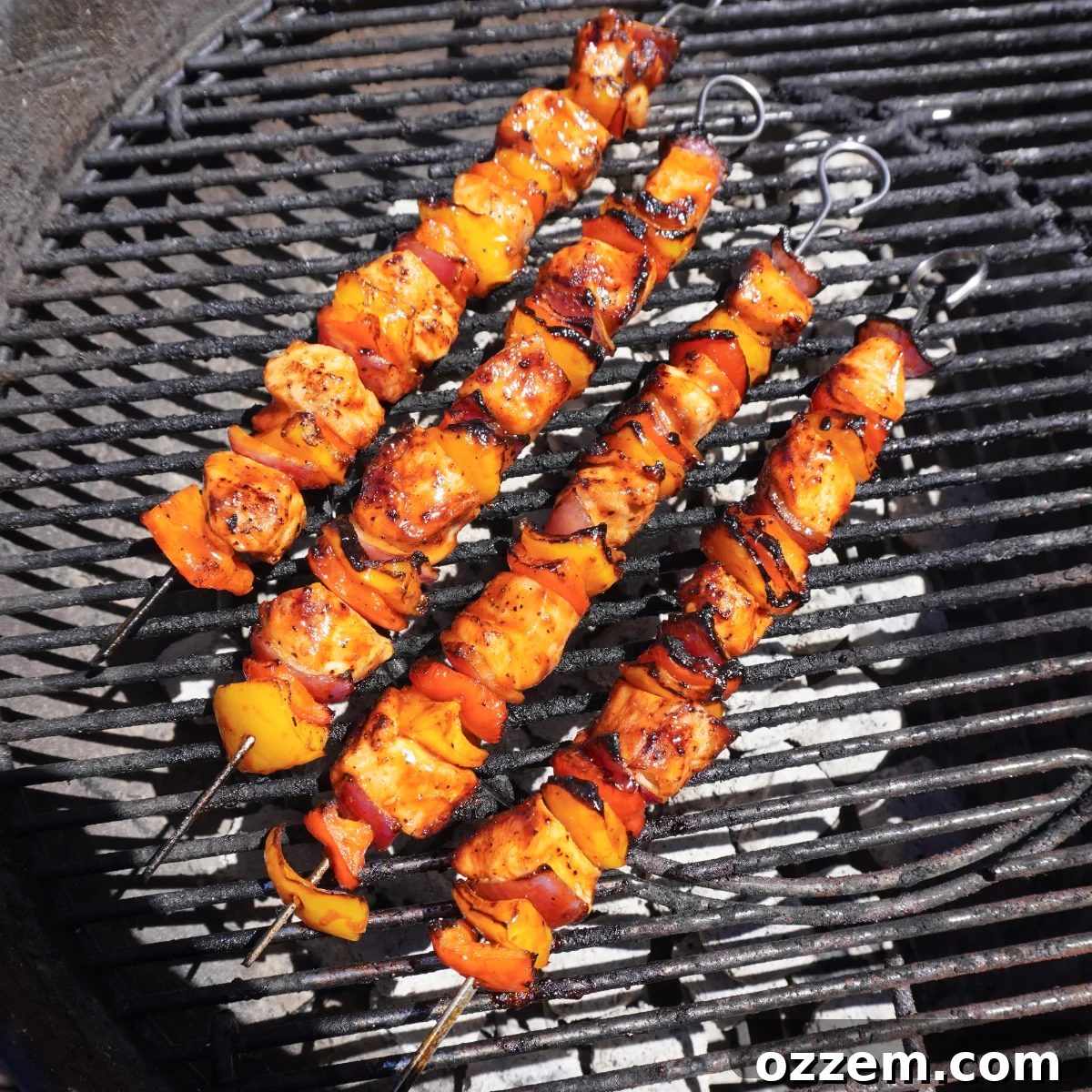 Grilled chicken and vegetable skewers sizzling on a hot grill, showing perfect char marks.