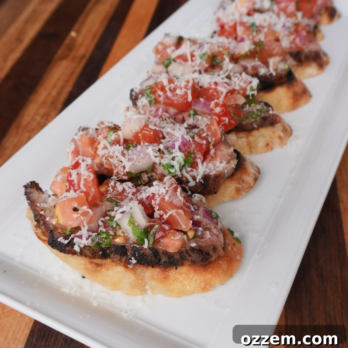 Chargrilled Steak Crostini 2 Delicious grilled steak bruschetta arranged on a wooden board, showcasing tender steak, fresh tomatoes, and golden-brown bread.