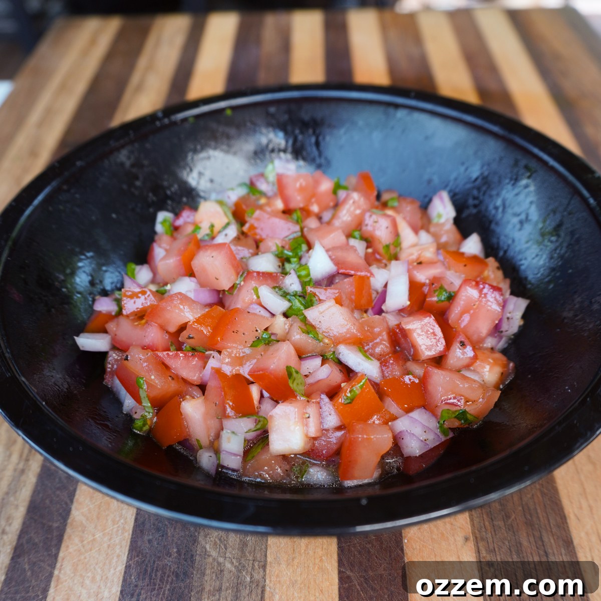 Chargrilled Steak Crostini 3 Freshly diced Roma tomatoes, red onion, and basil mixed in a bowl, glistening with olive oil for bruschetta topping.
