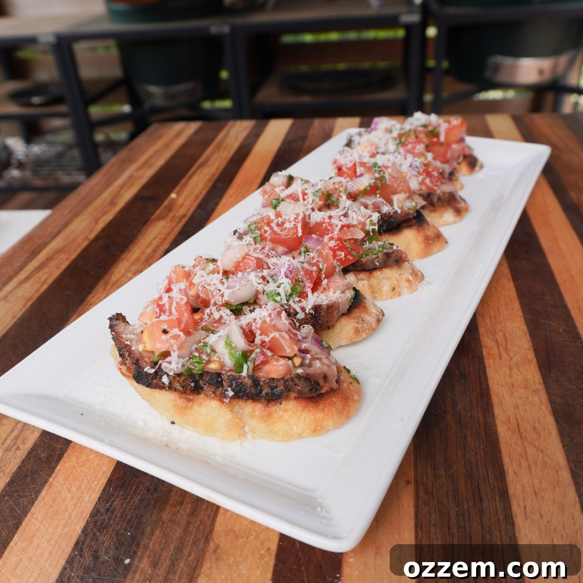 Chargrilled Steak Crostini 7 Assembled grilled steak bruschetta with roasted garlic butter spread, succulent steak slices, fresh tomato topping, and grated Parmesan cheese.