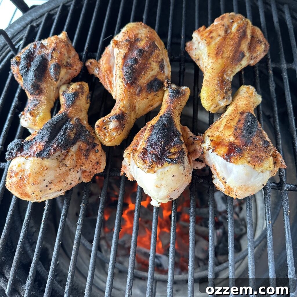 Grilled chicken drumsticks in dr pepper bbq sauce on a hot grill.