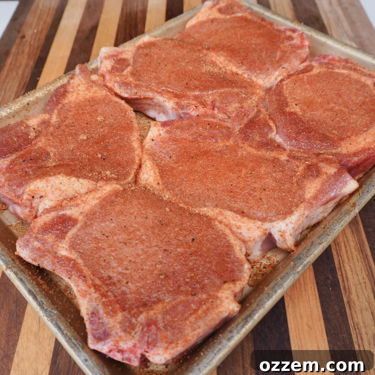 Seasoning thick bone-in pork chops with Dad's Maple Bourbon Rub.