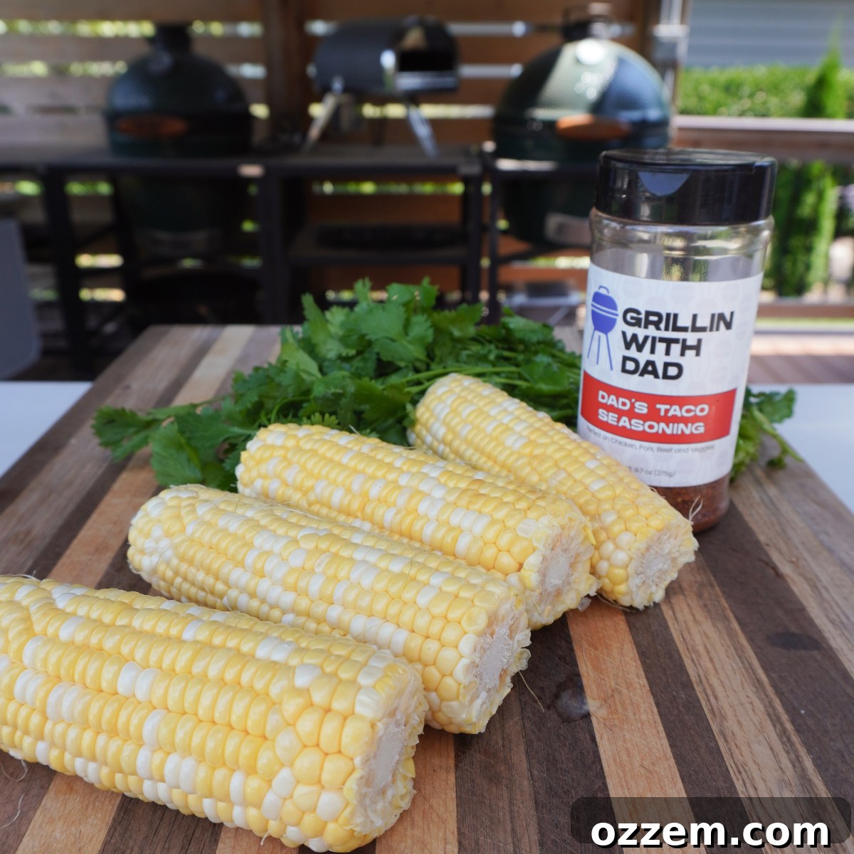 Close-up of corn on the cob being prepared, with husks peeled back and ready for seasoning