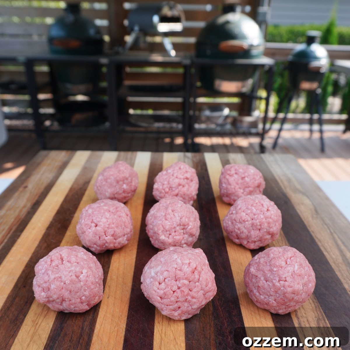 Small, evenly shaped round raw beef balls on a cutting board, ready for smashing.