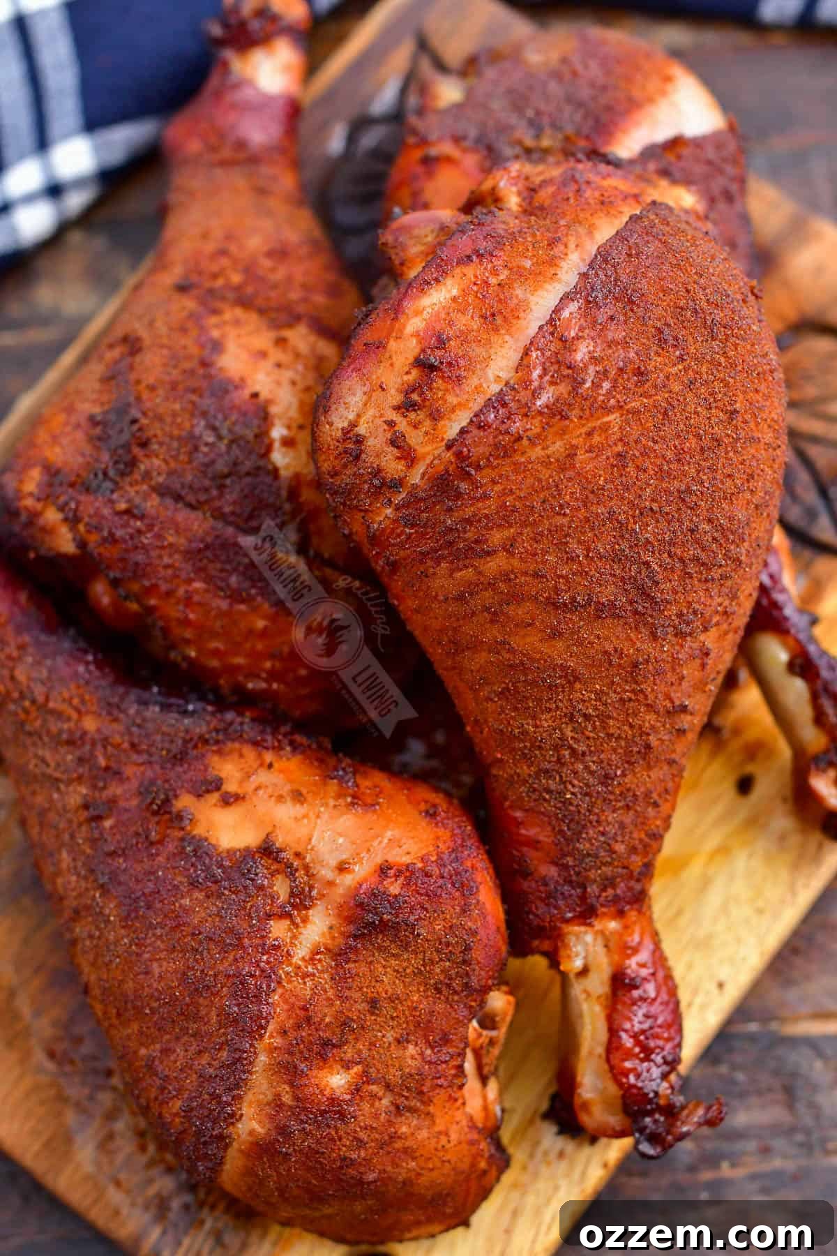 smoked turkey legs stacked on a wooden plate
