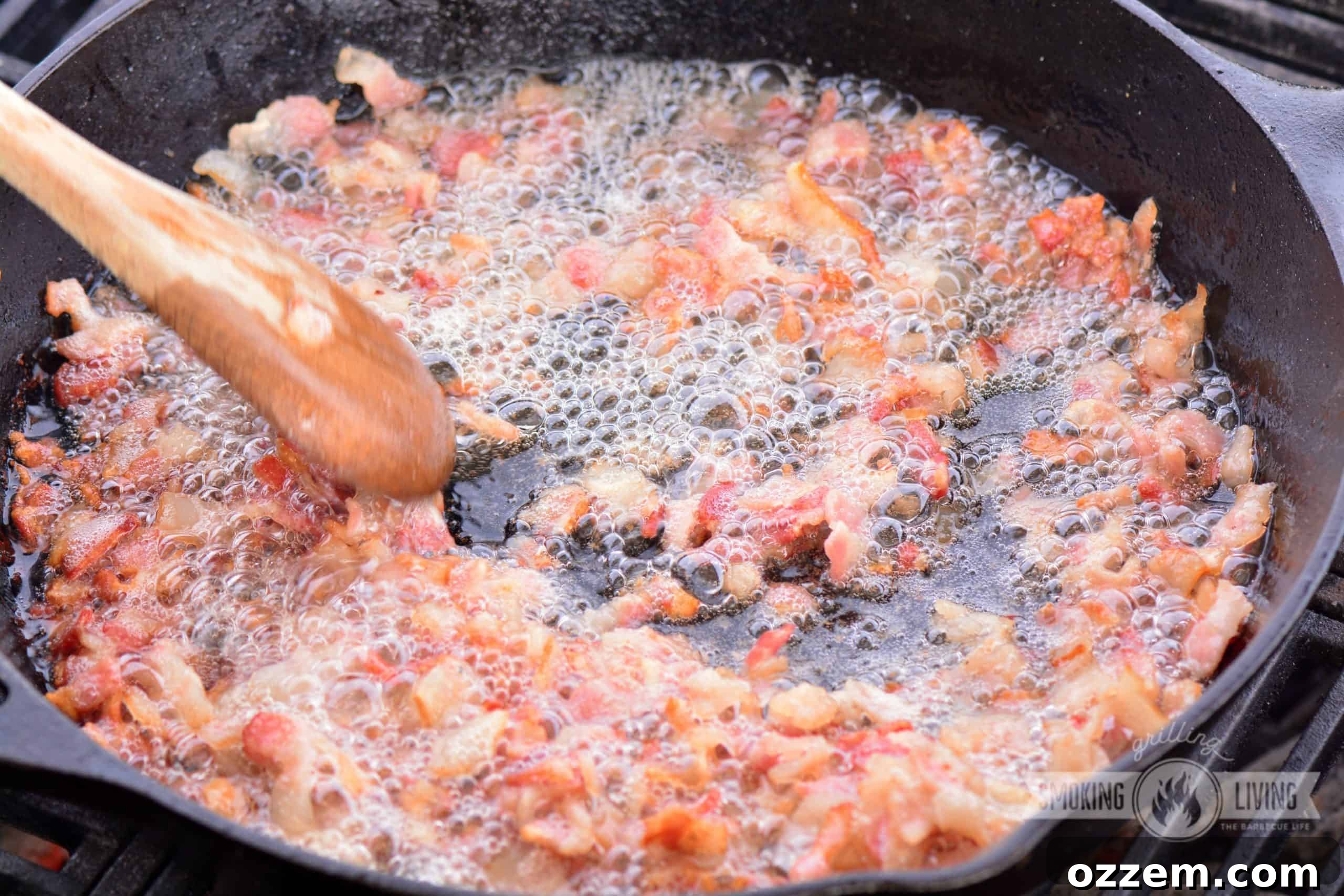 Cooking bacon in a cast iron skillet on the grill for bacon jam