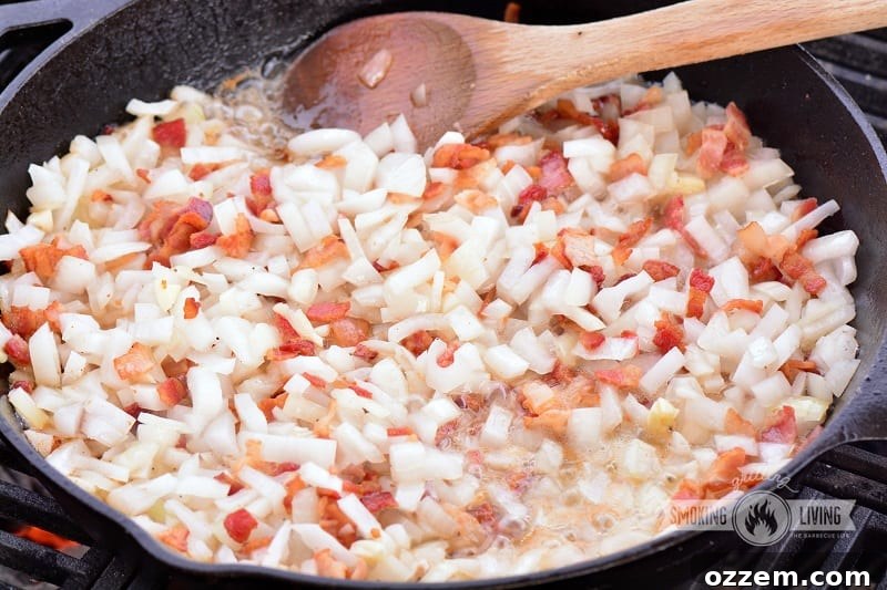 Onions and bacon caramelizing in a skillet on the grill