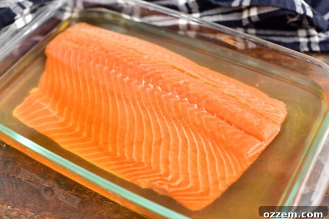 Salmon fillet submerged in brine in a clear glass baking dish