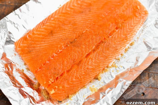 Salmon fillet on aluminum foil, lightly seasoned with sugar, salt, and pepper