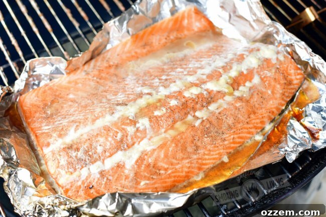 Cooked hot smoked salmon resting on foil on a smoker grate