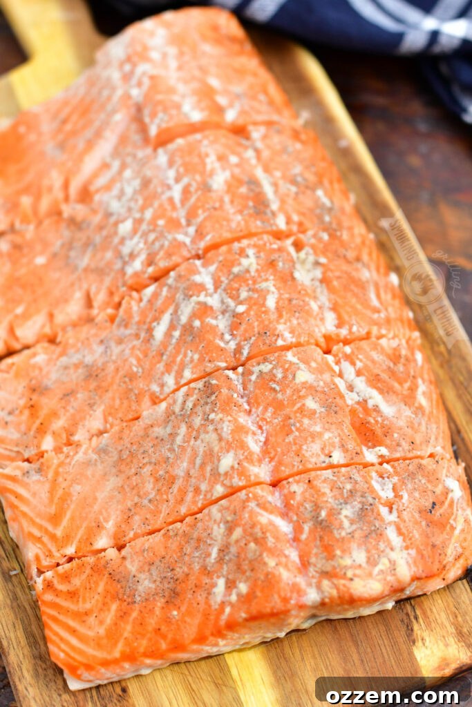 A whole side of hot smoked salmon, sliced, on a wooden cutting board