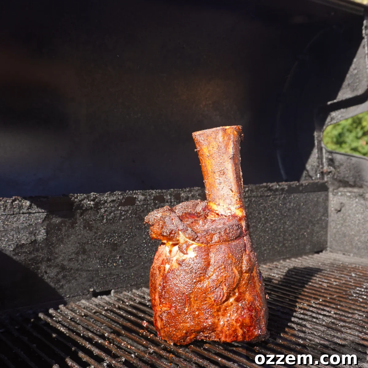Beef shank smoking upright on the grill.