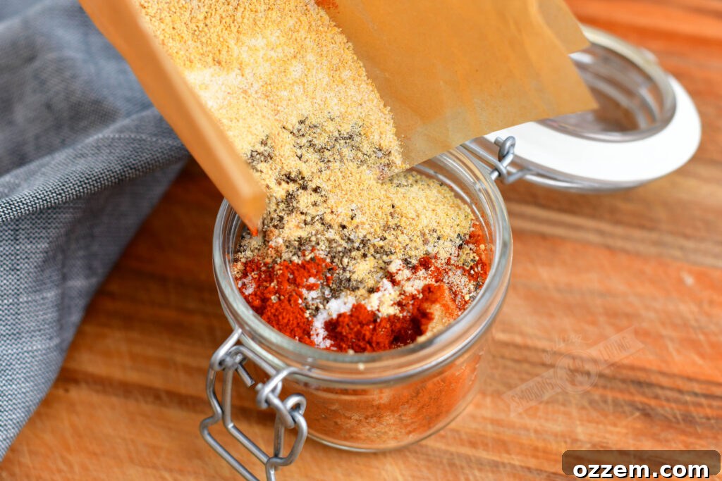 Pouring the blended spice mix into a glass jar for storage