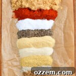 Spices for rib rub lined up next to each other on parchment paper