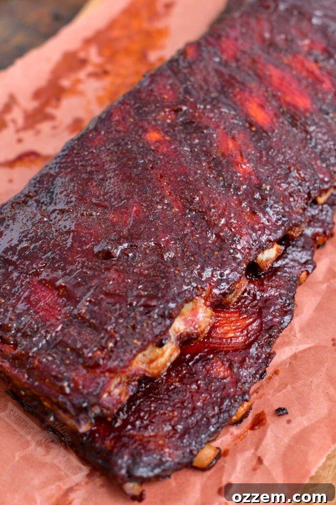 Two stacked St. Louis racks of smoked ribs wrapped in butcher paper, indicating they've just come off the smoker and are resting.