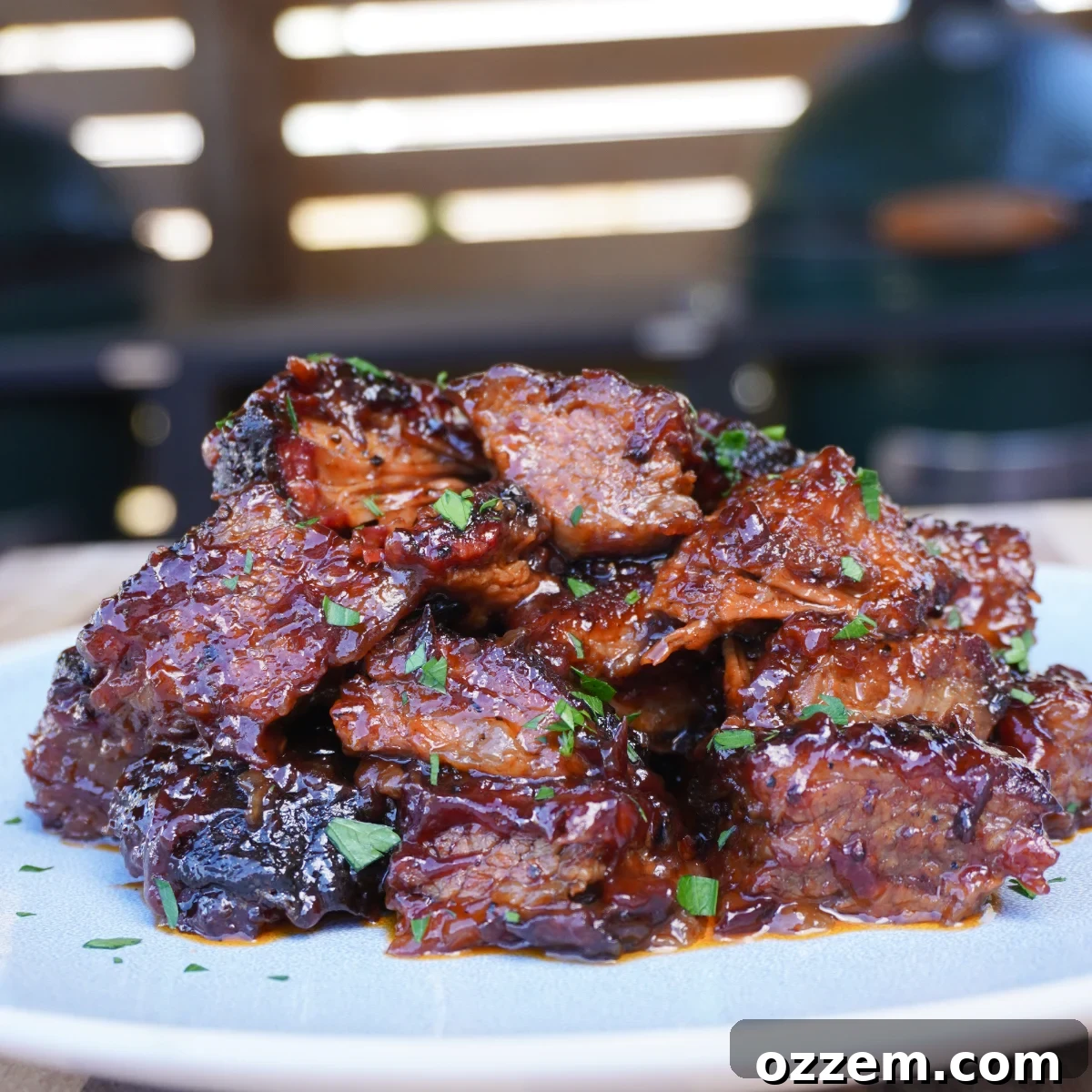 Brisket burnt ends, glistening with sweet and savory BBQ sauce, piled high on a plate