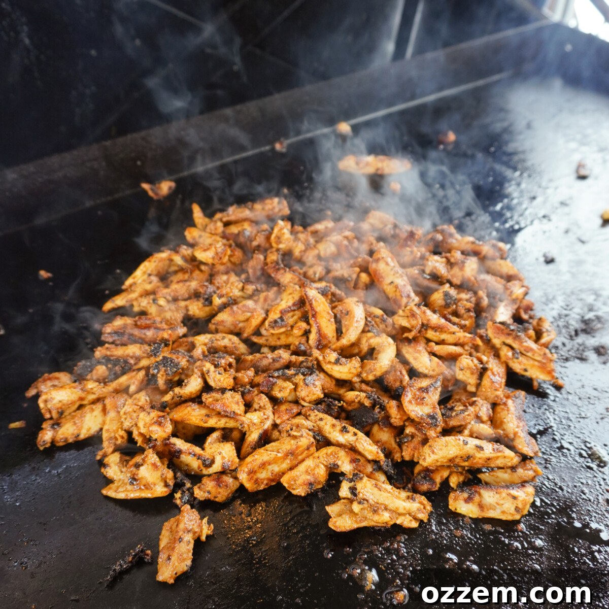 Flame Kissed Chicken Shawarma 8 Marinated chicken shawarma strips sizzling on a hot griddle.