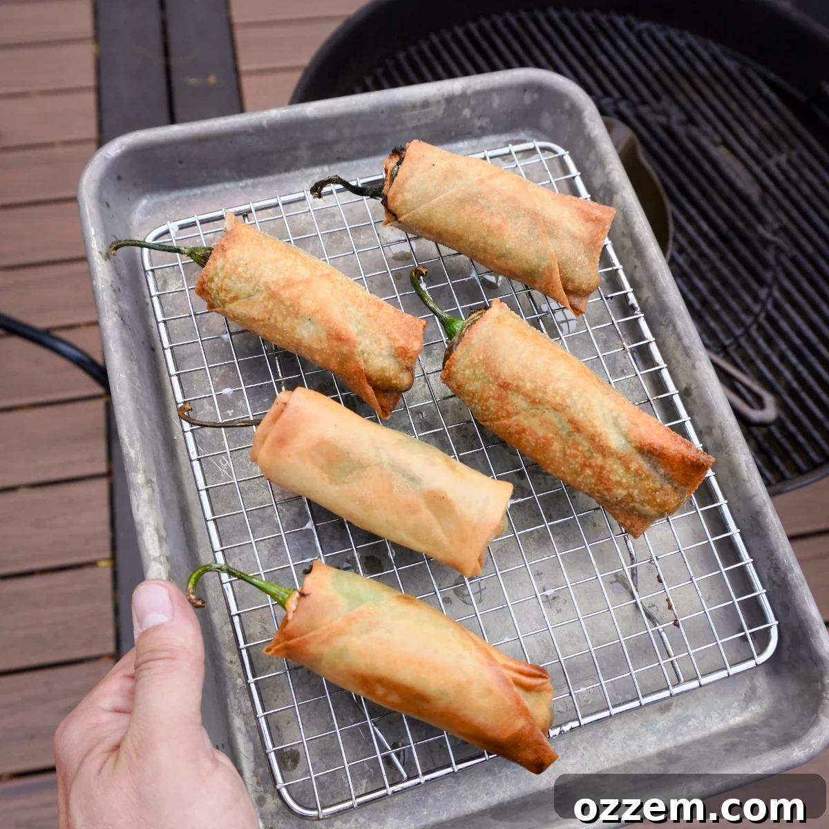 Crispy Jalapeno Popper Lumpia 14 Deep fried jalapeno popper lumpia's resting on a wire rack to drain excess oil.