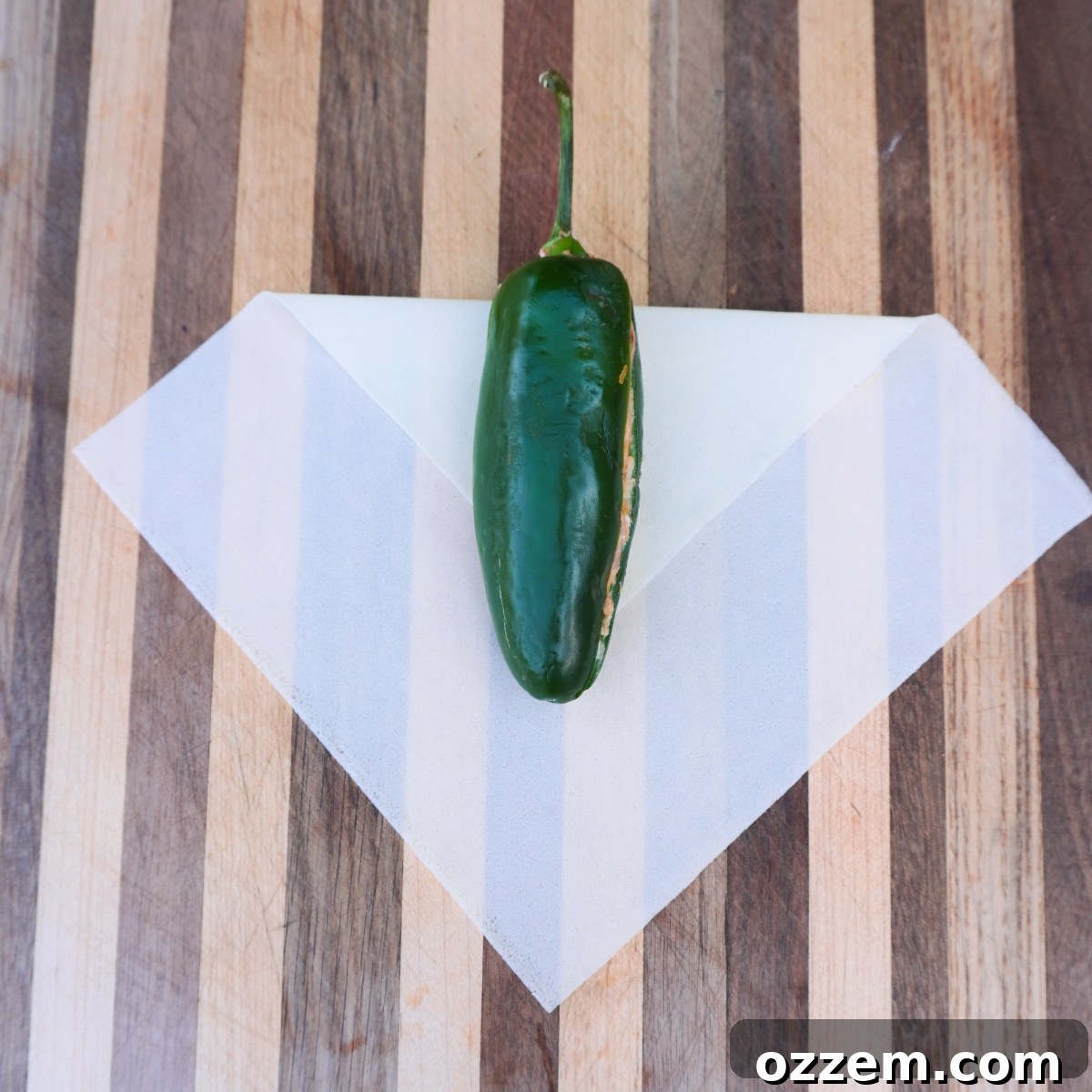 Crispy Jalapeno Popper Lumpia 8 Step-by-step image of folding a lumpia wrapper, showing the initial placement of the jalapeno.
