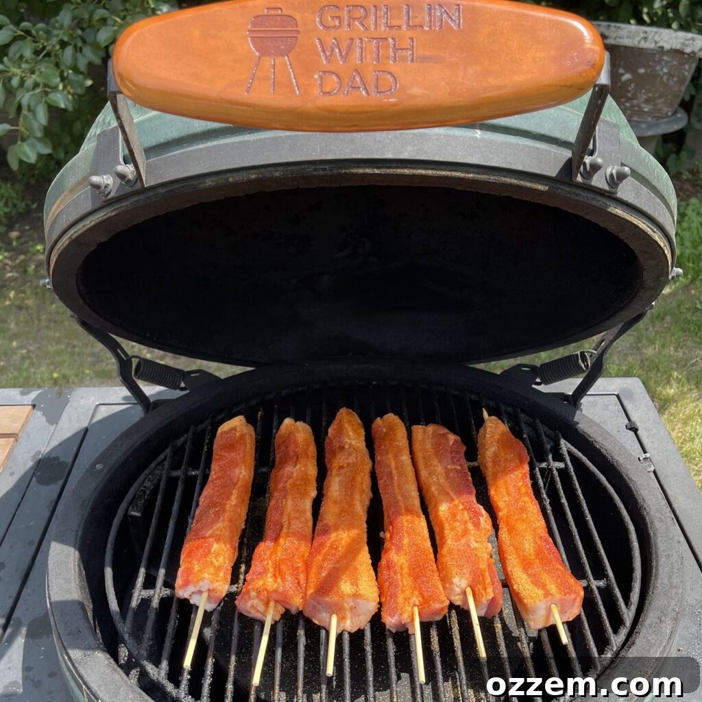 Pork belly skewers on the grill, slowly smoking to perfection.