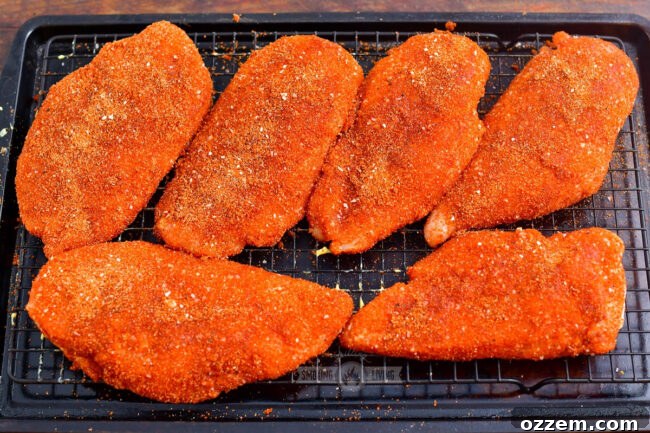 Tender & Smoky Chicken Breast Perfection 6 Generously seasoned raw chicken breasts arranged on a wire rack, ready for smoking