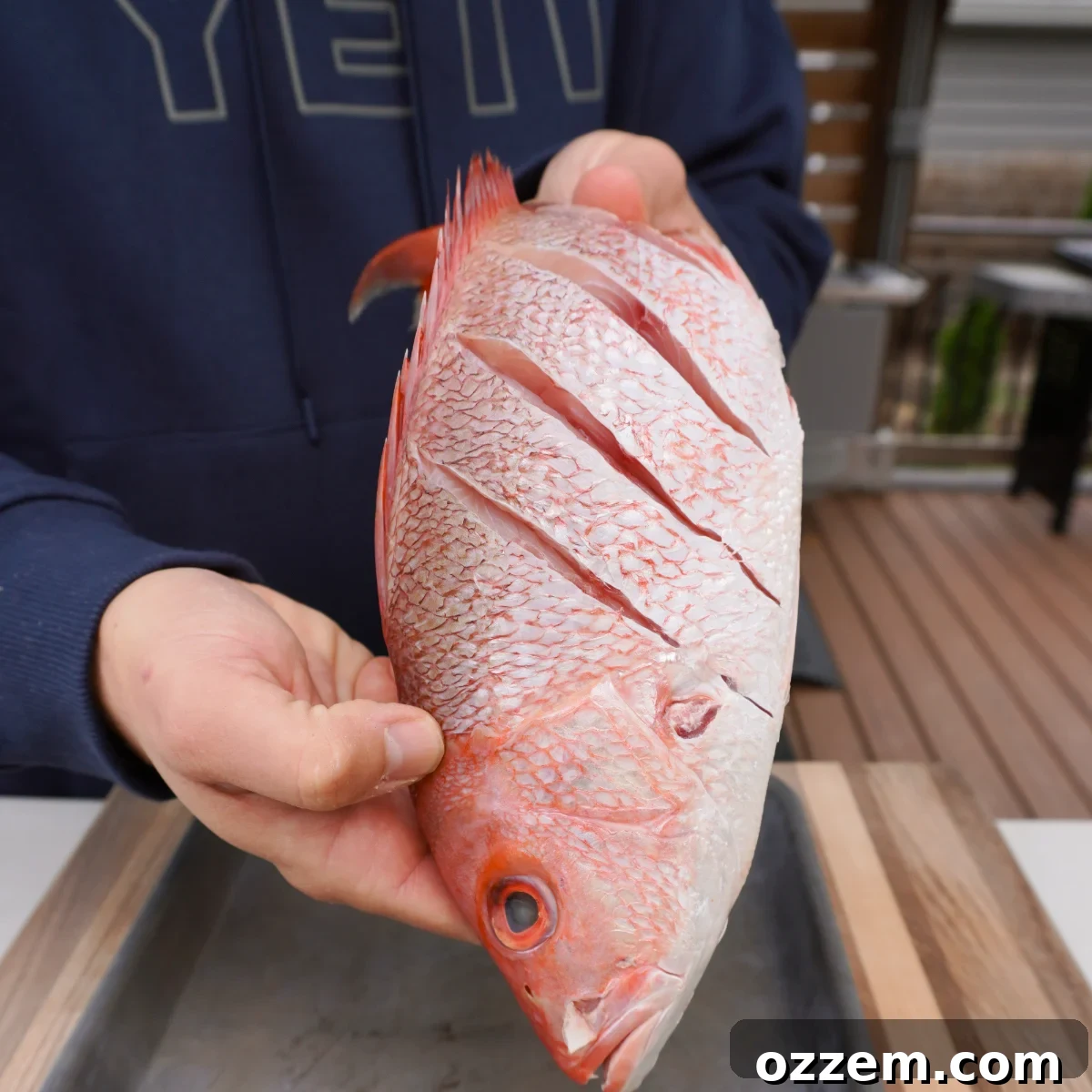 Flame-Kissed Red Snapper 4 Scored raw red snapper on a cutting board, ready for seasoning.