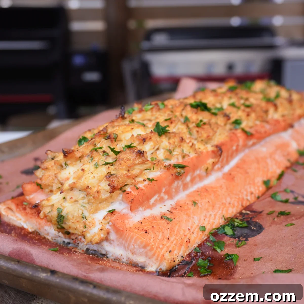 smoked crab stuffed salmon filet on butcher paper, garnished with fresh herbs and lemon wedges.