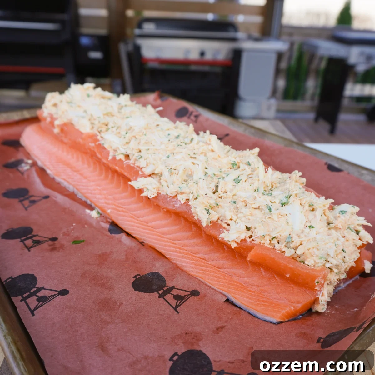 Raw crab stuffed salmon fillet on butcher paper, ready to be grilled or smoked.