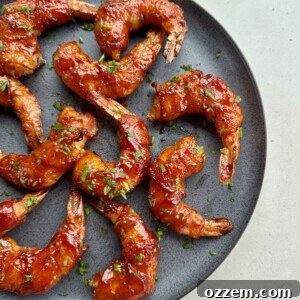 Juicy BBQ bacon-wrapped shrimp skewers on a serving plate, ready to be enjoyed.