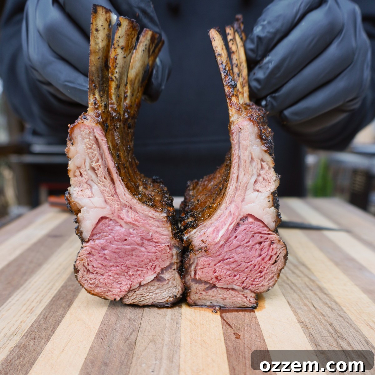 sliced in half rack of lamb cooked to a perfect medium rare, revealing its juicy interior.