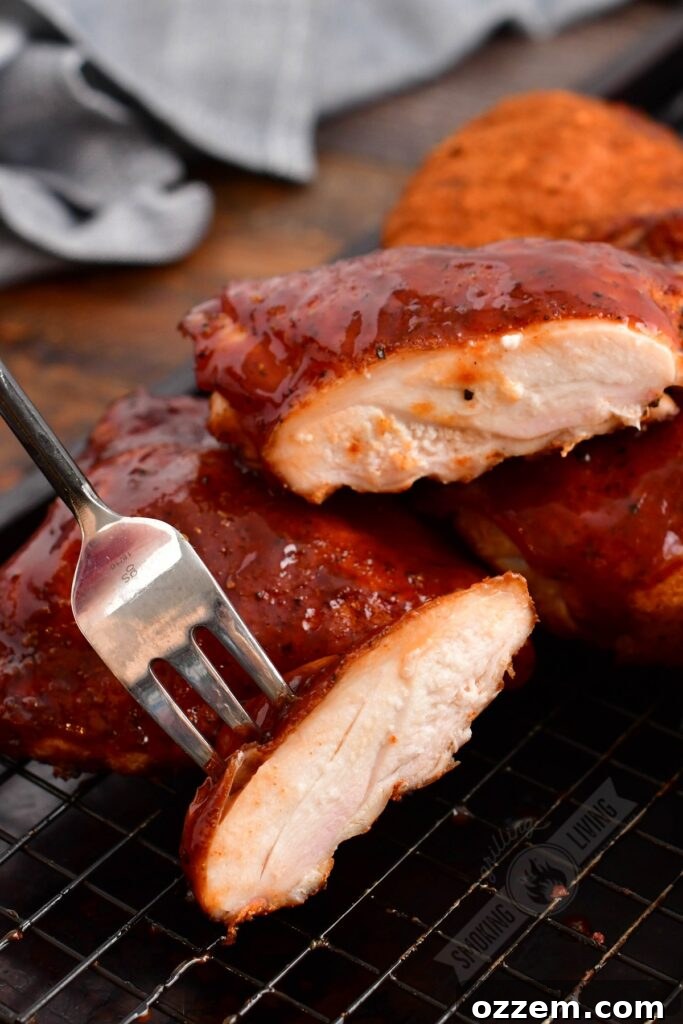 smoked chicken thigh cut in half with a fork holding one piece