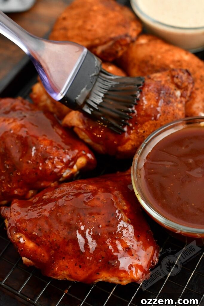 chicken thighs cooked coated in BBQ sauce and brushing one with sauce