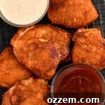 top view of smoked chicken thighs with two sauces in bowls