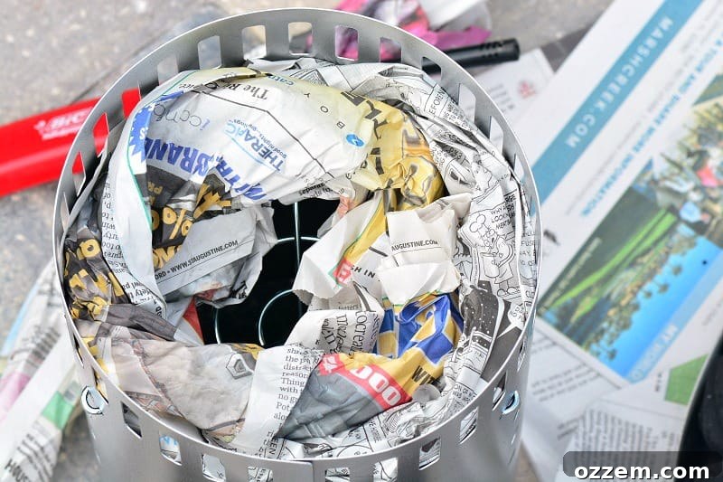 Rolled newspaper neatly inserted in a circular pattern inside a charcoal chimney starter