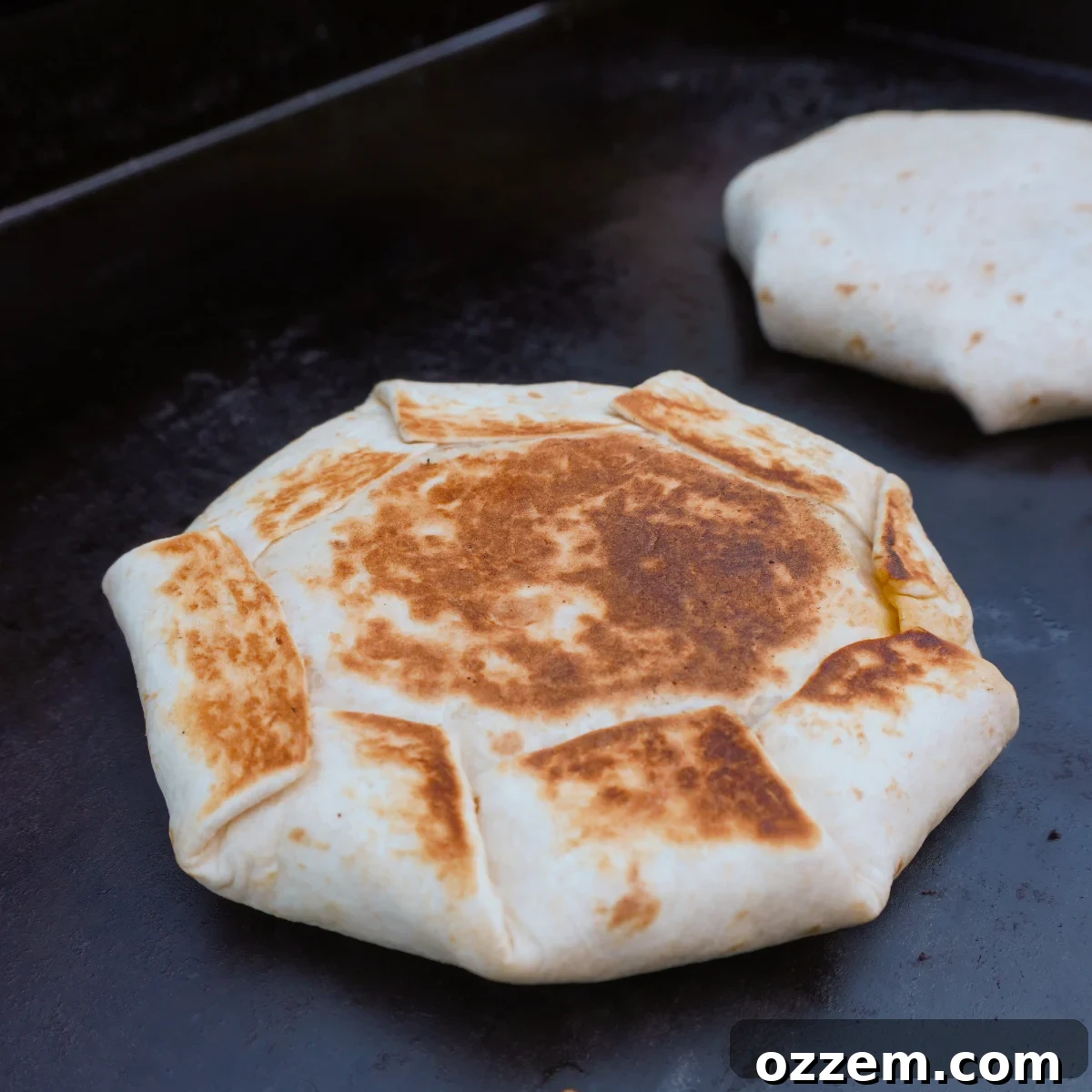 A fully assembled, folded Chopped Cheese Crunchwrap, ready for grilling.