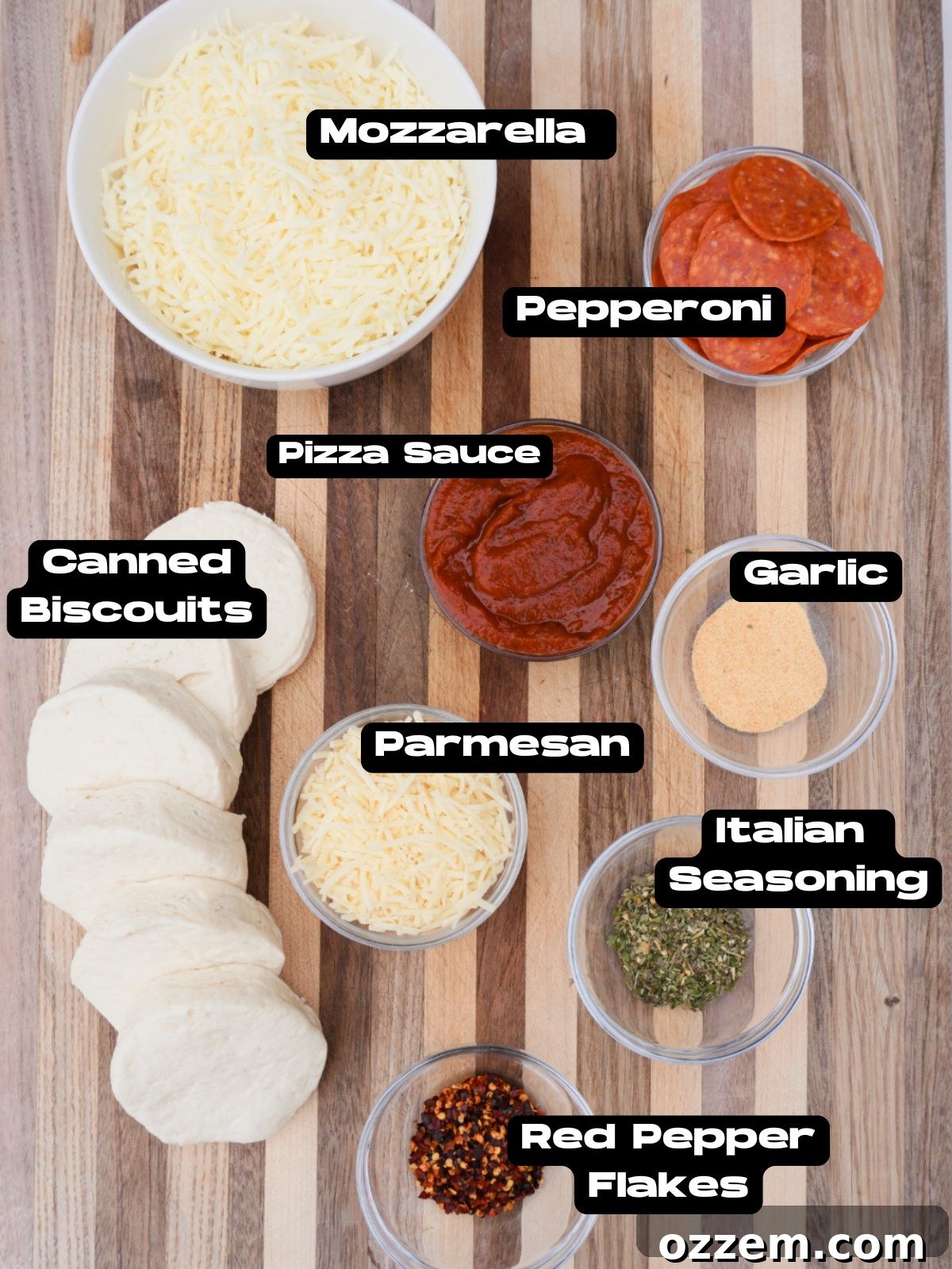 Layout of ingredients for the pull apart pepperoni pizza including biscuits, sauce, cheeses, and pepperoni on a kitchen counter