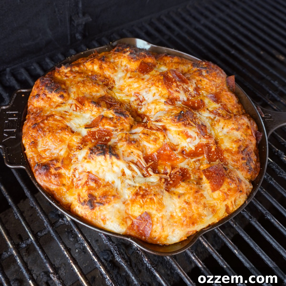 Pull Apart Pepperoni Pizza cooking on a charcoal grill with indirect heat setup, showing steam rising