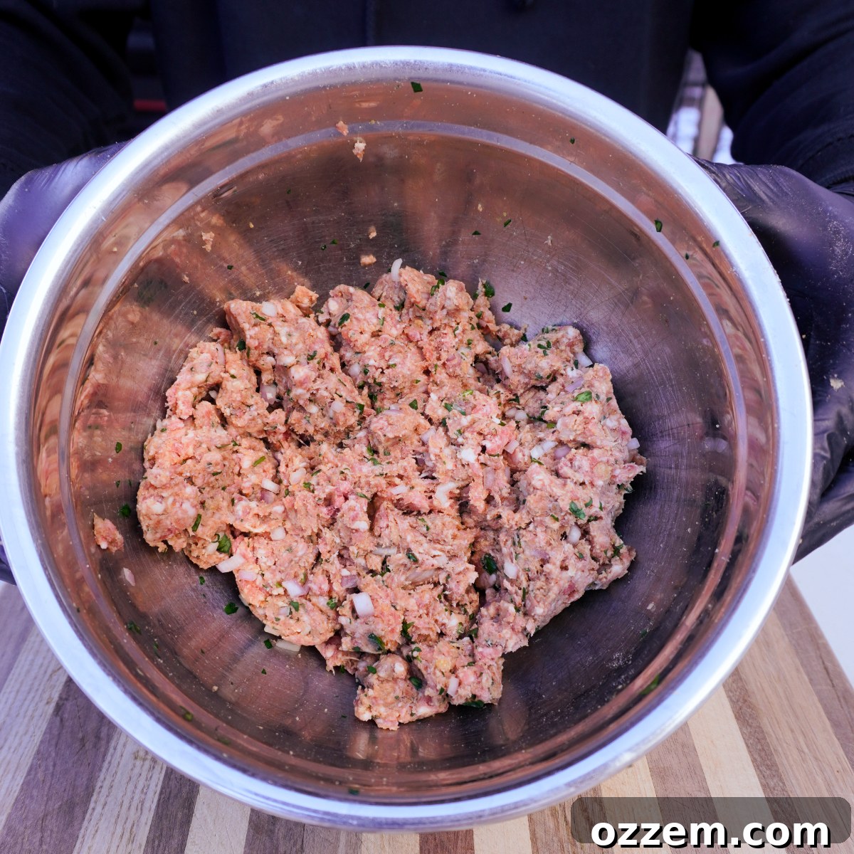 Meatball mixture in a metal bowl, ready for mixing.