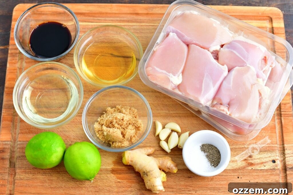 Zesty Grilled Ginger Lime Chicken Thighs 3 Fresh ingredients for chicken thighs and marinade, including limes, ginger, garlic, and oil, neatly arranged on a wooden cutting board
